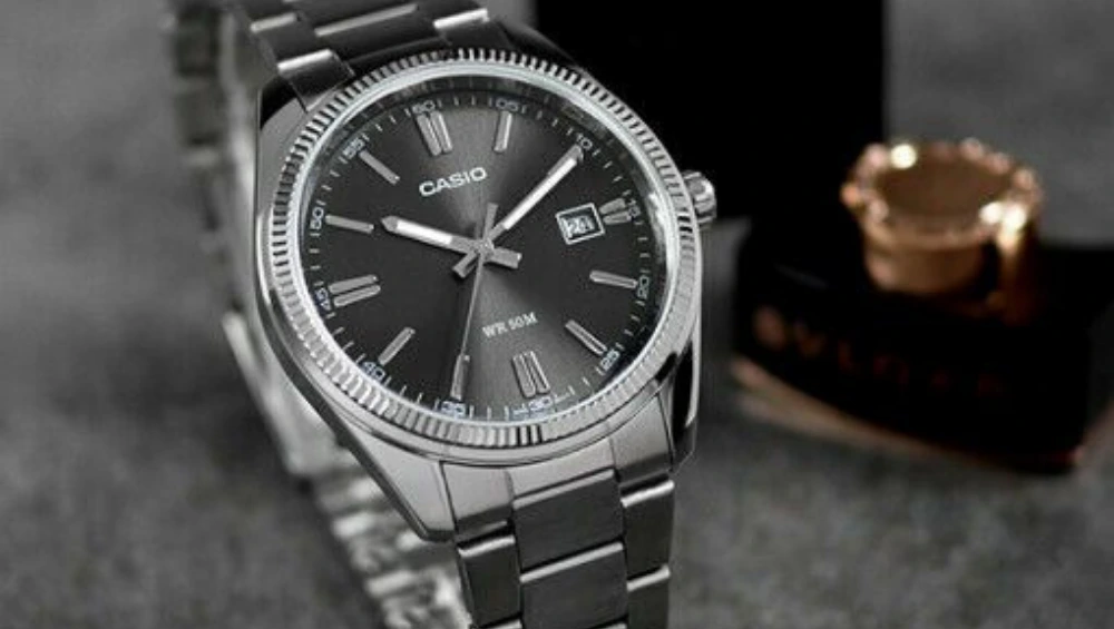 A close-up of a sleek Casîo digital wristwatch resting on a marble surface, showcasing its minimalist design and digital display.