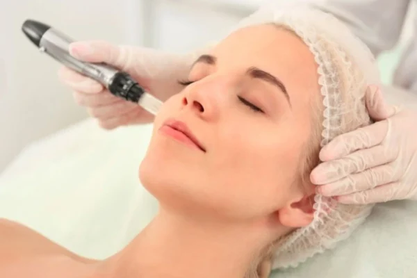 "Client receiving treatment at one of the top micro-needling clinics with a professional using a dermapen device"