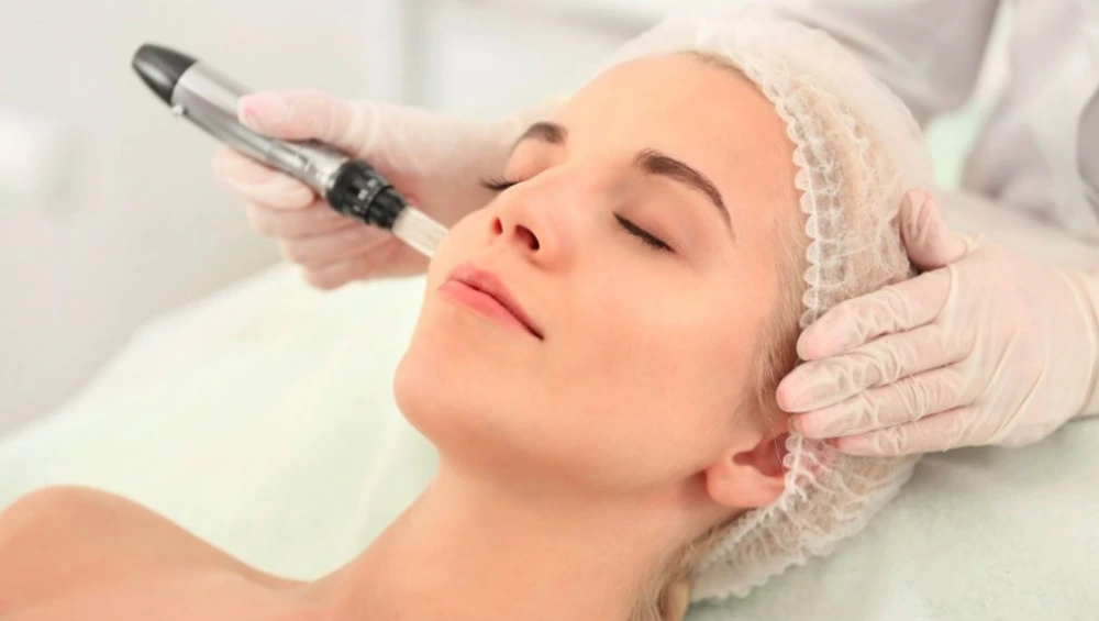 "Client receiving treatment at one of the top micro-needling clinics with a professional using a dermapen device"