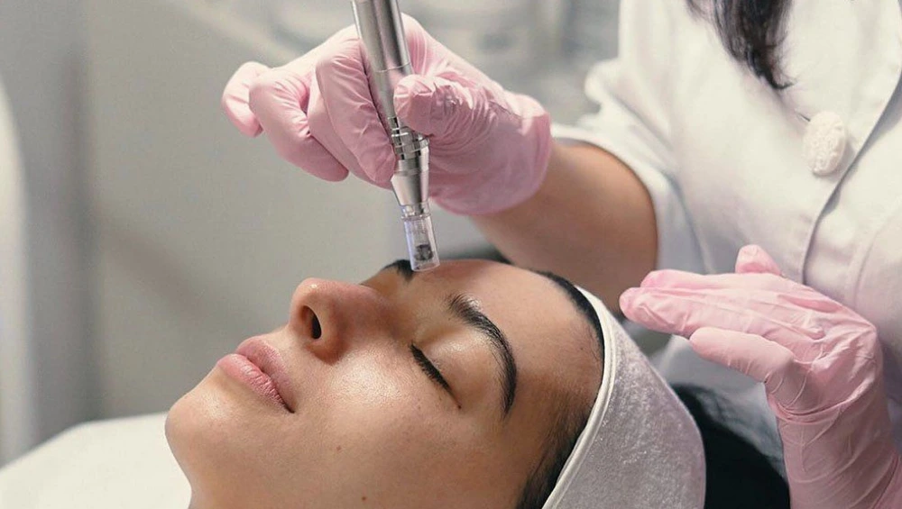 "Client receiving treatment at one of the top micro-needling clinics with a professional using a dermapen device" 