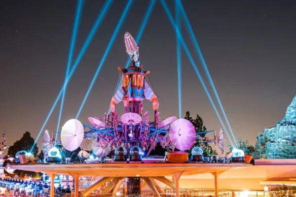Guests enjoying a nighttime view of fireworks from the Tomorrowland Skyline Terrace at Disneyland.