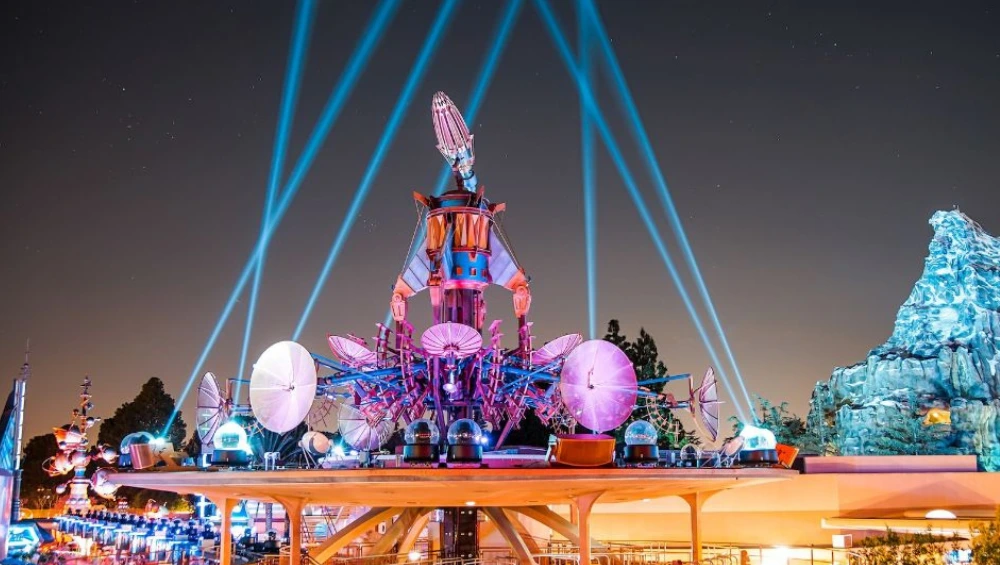 Guests enjoying a nighttime view of fireworks from the Tomorrowland Skyline Terrace at Disneyland.
