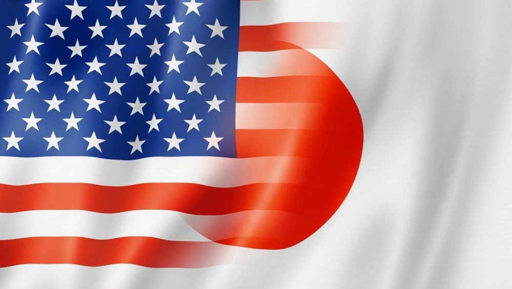 U.S and Japanese officials shaking hands after signing the US Japan Trade Agreement, with national flags in the background.