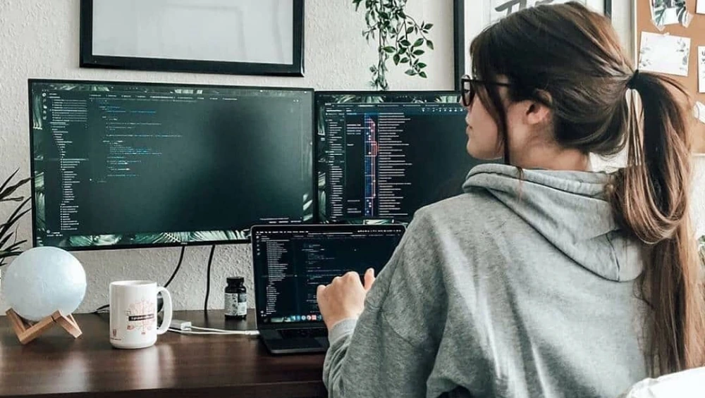A young girl learning to code on a laptop during a girls in tech workshop.