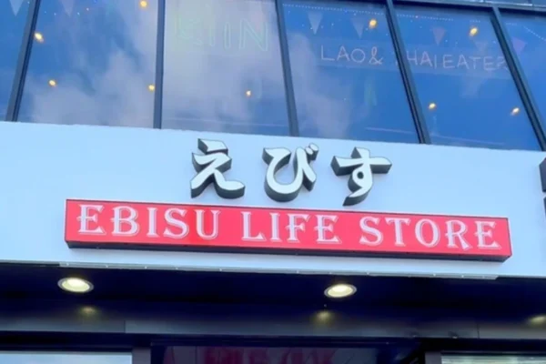 Bright storefront of the Ebisu Japanese Lifestyle Store showing the bold “EBISU” logo above a welcoming entrance, with patrons inside browsing the diverse selection.