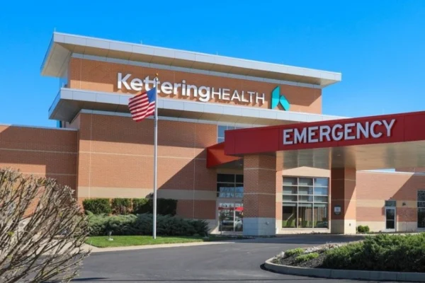 Graphic showing a cybersecurity breach with the Kettering Health logo and warning symbol, illustrating the Kettering Health ransomware attack.