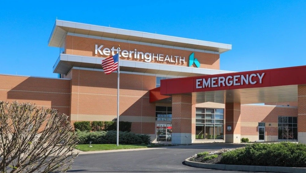 Graphic showing a cybersecurity breach with the Kettering Health logo and warning symbol, illustrating the Kettering Health ransomware attack.