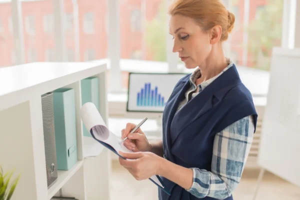 Profissional criando protocolo operacional padrao com documentos, checklists e fluxogramas em ambiente corporativo moderno