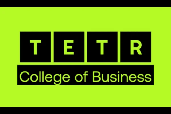 Group of international students standing in front of the TETR College of Business logo at an orientation event, showcasing a modern collaborative learning environment.
