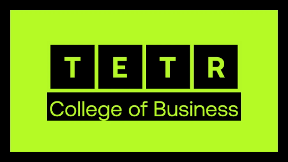 Group of international students standing in front of the TETR College of Business logo at an orientation event, showcasing a modern collaborative learning environment.